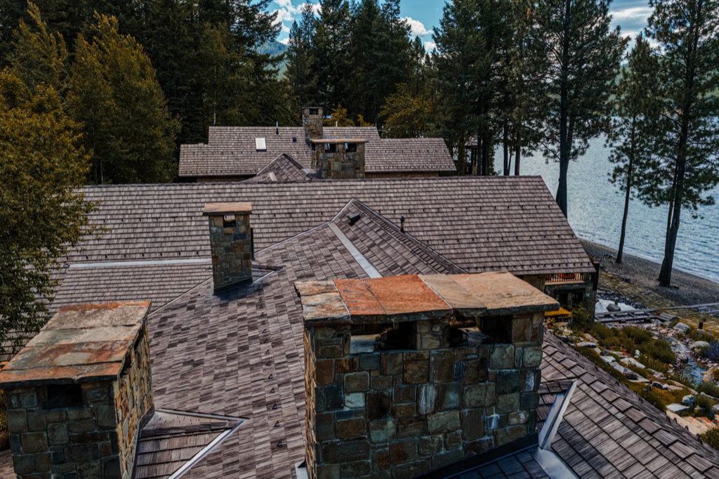 Synthetic shake on a lakefront estate, with stone chimneys and metal caps